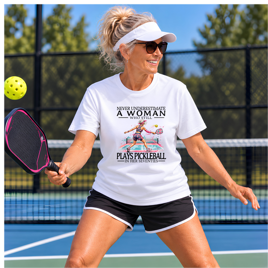 Never Underestimate a Woman Who Still Plays Pickleball in Her Seventies – Women’s Gildan Heavy Cotton Tee